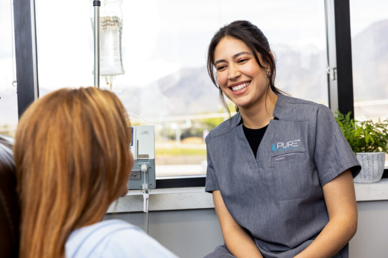 Smiling nurse helps patient with infusion at ambulatory infusion center